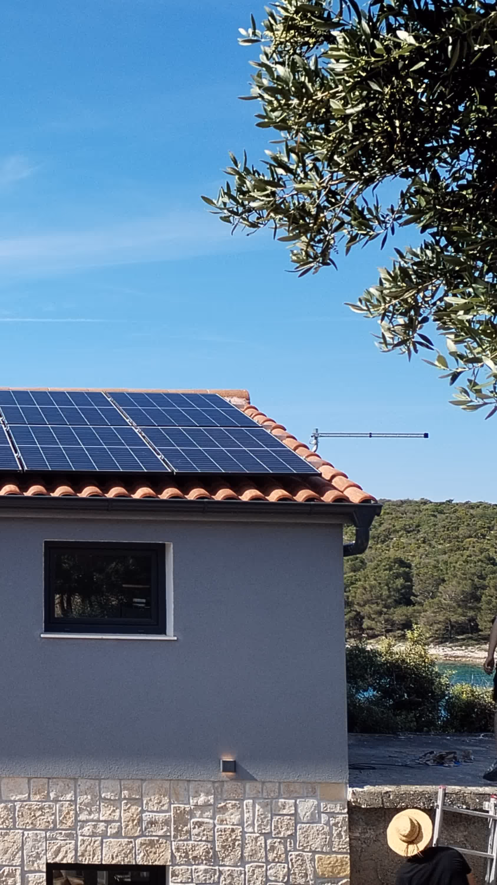 Solarni paneli na krovu objekta u zlatnom svjetlu zalaska sunca