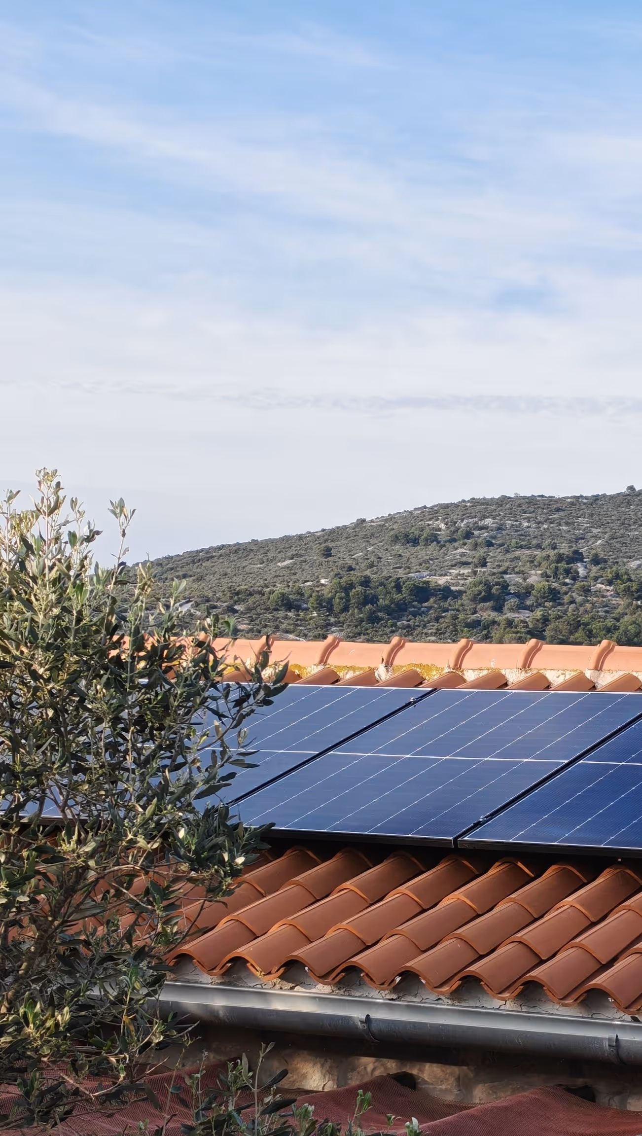 Solarni paneli na krovu objekta u zlatnom svjetlu zalaska sunca